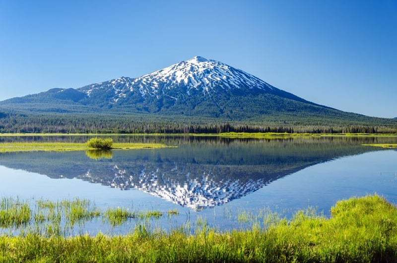lake with reflection of mountain in background